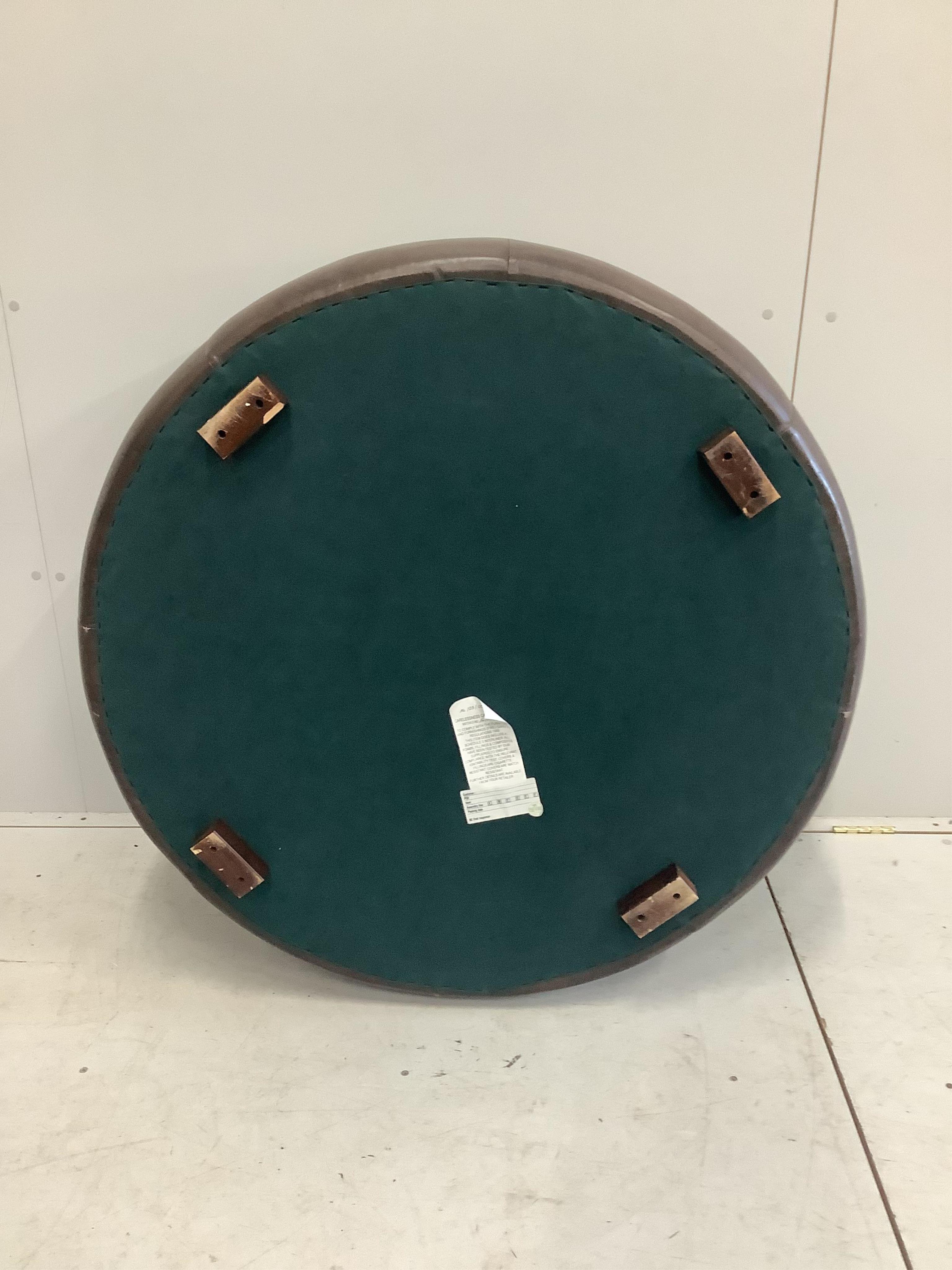 A circular brown leather footstool, diameter 100cm, height 36cm. Condition - good